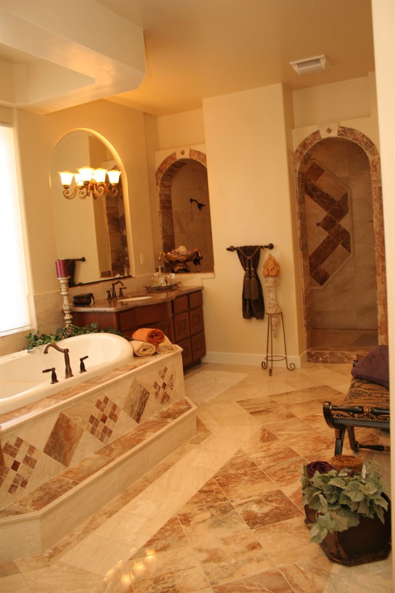 Master bathroom with a tiled soaking tub surround and arched alcoves