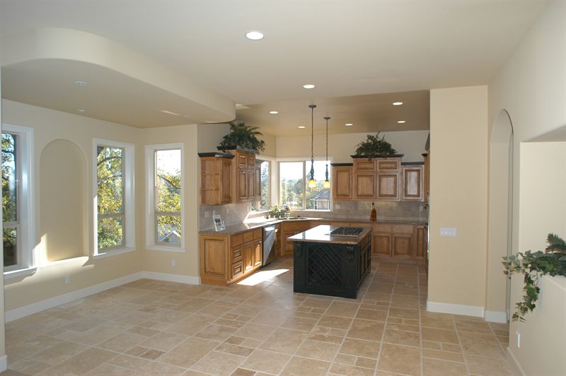 Open-plan kitchen with tile flooring opening onto a bright living space