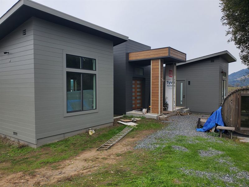 Finished modern home with dark cladding and a timber entry canopy
