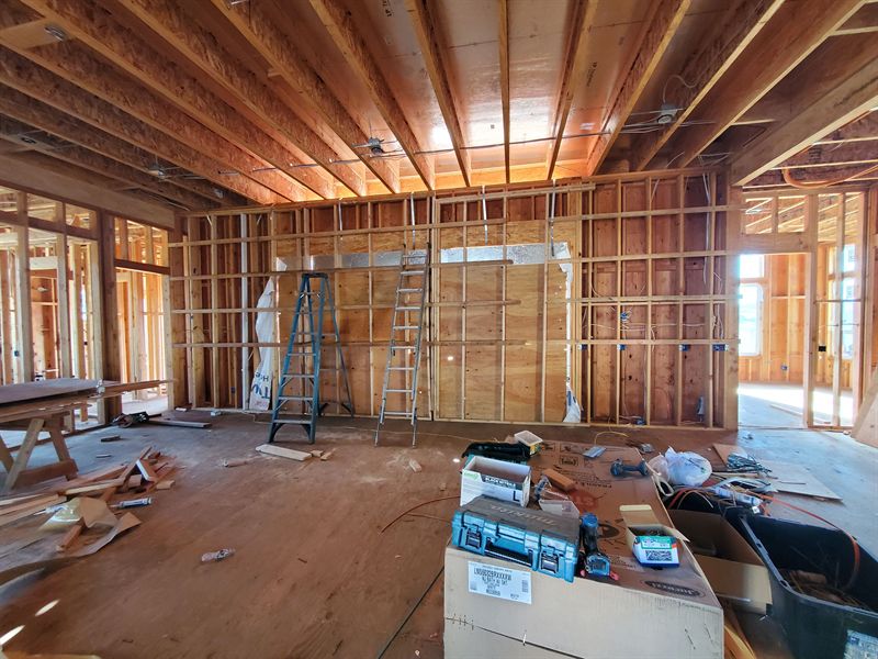 Interior of a framed house with exposed timber ceiling and wide openings