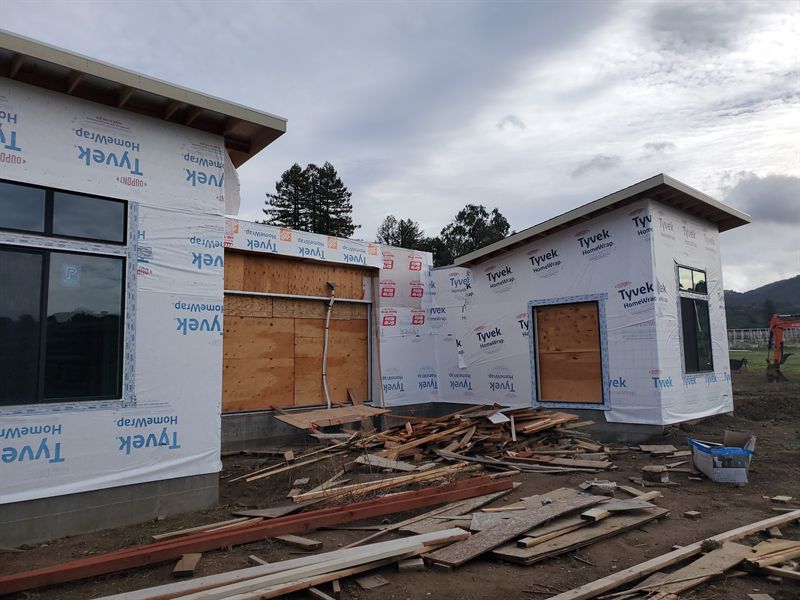 House sheathed and wrapped in weather membrane with windows fitted